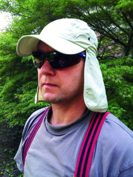 Vergrößerung des Bildes für junger Mann mit Sonnenbrille, Kopfbedeckung mit Nackenschutz.