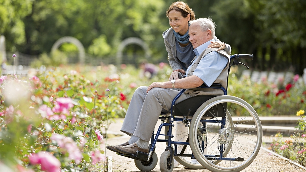 Vergrößerung des Bildes für Pflegerin mit Senior im Rollstuhl.