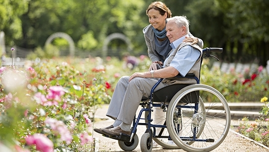 Pflegerin mit Senior im Rollstuhl
