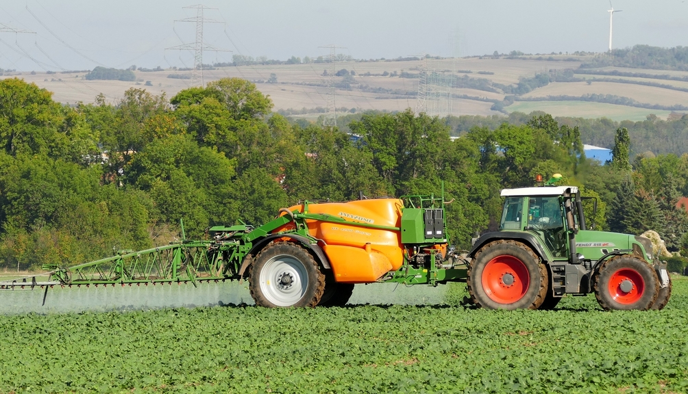 Vergrößerung des Bildes für Traktor mit Pflanzenschutzgerät auf dem Feld im Einsatz.