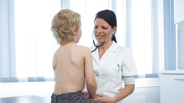 Vergrößerung des Bildes für Eine Ärztin untersucht ein Kleinkind mit einem Stethoskop.